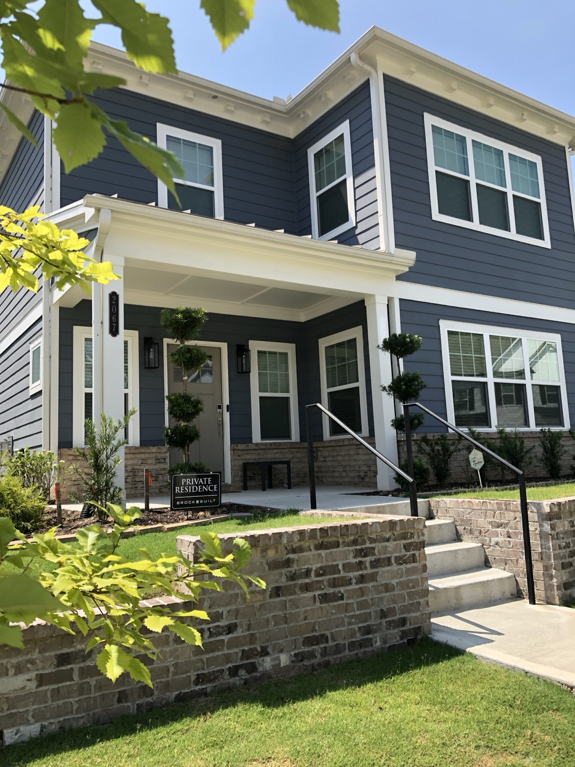 A blue home with a landscaped front entrance