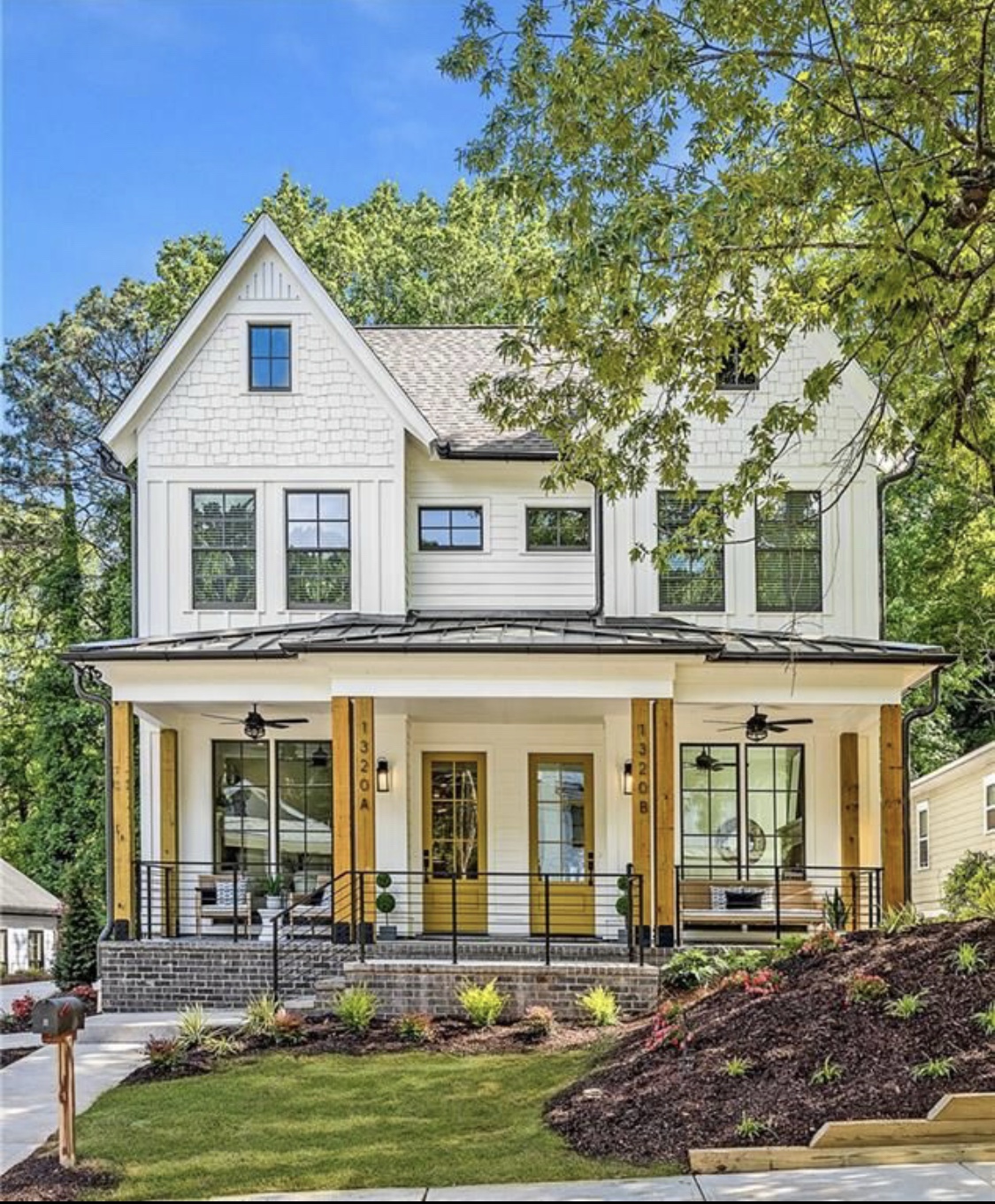 A white home with yellow doors and a welcoming front porch